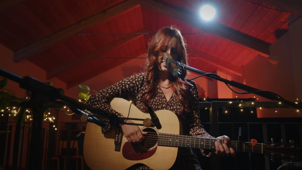 Aurora D'Amico canta con la chitarra acustica al Wood Factory